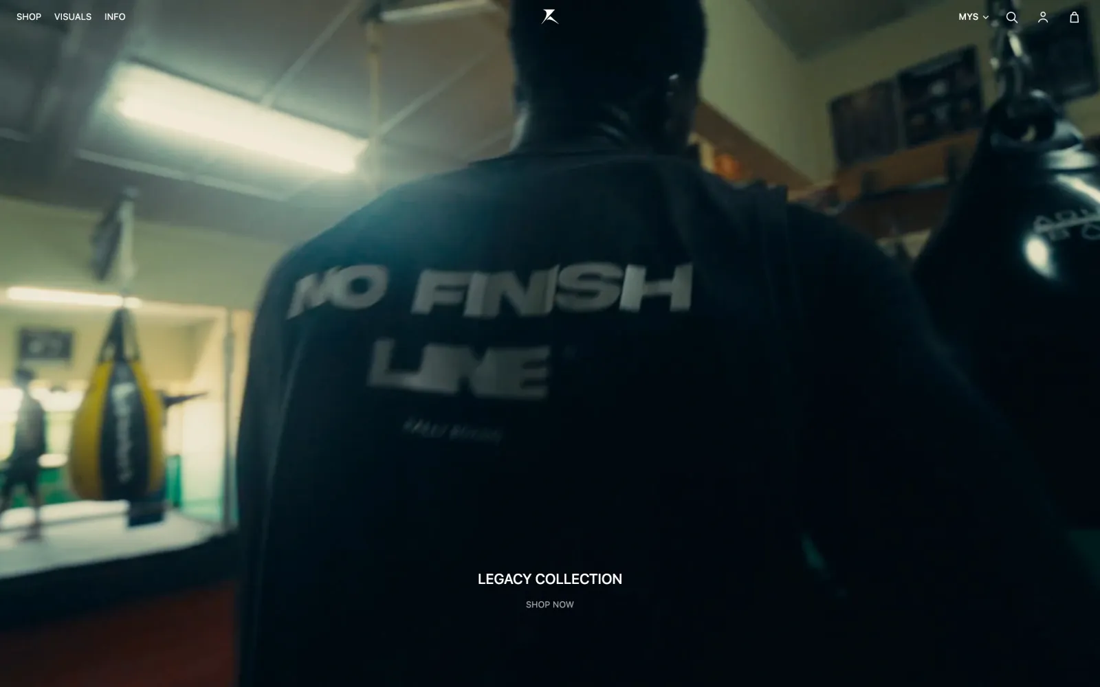 Rally Boxing homepage: a boxer in a “No Finish Line” shirt in a gym, over the Legacy Collection